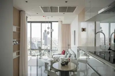 Modern living room with panoramic city view, stylish furniture, and open kitchen layout.
