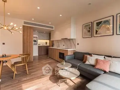 Modern living room with stylish decor and open kitchen layout, featuring elegant lighting and cozy seating.