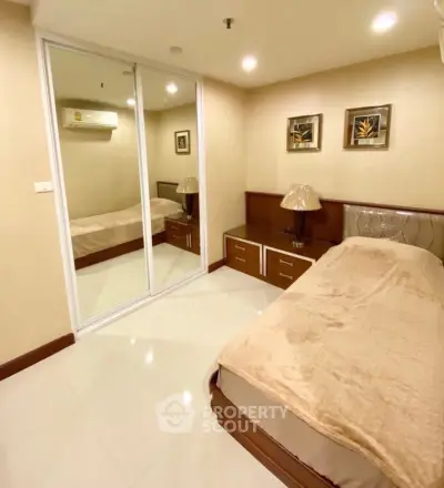 Cozy bedroom with mirrored closet and elegant decor in modern apartment