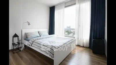 Modern bedroom with large window and stylish decor in urban apartment