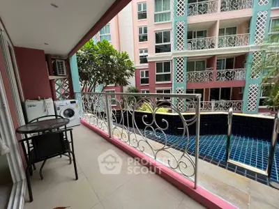 Spacious balcony overlooking a luxurious pool in a modern apartment complex.