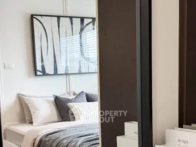 Stylish modern bedroom with cozy bedding and contemporary artwork, perfect for relaxation.