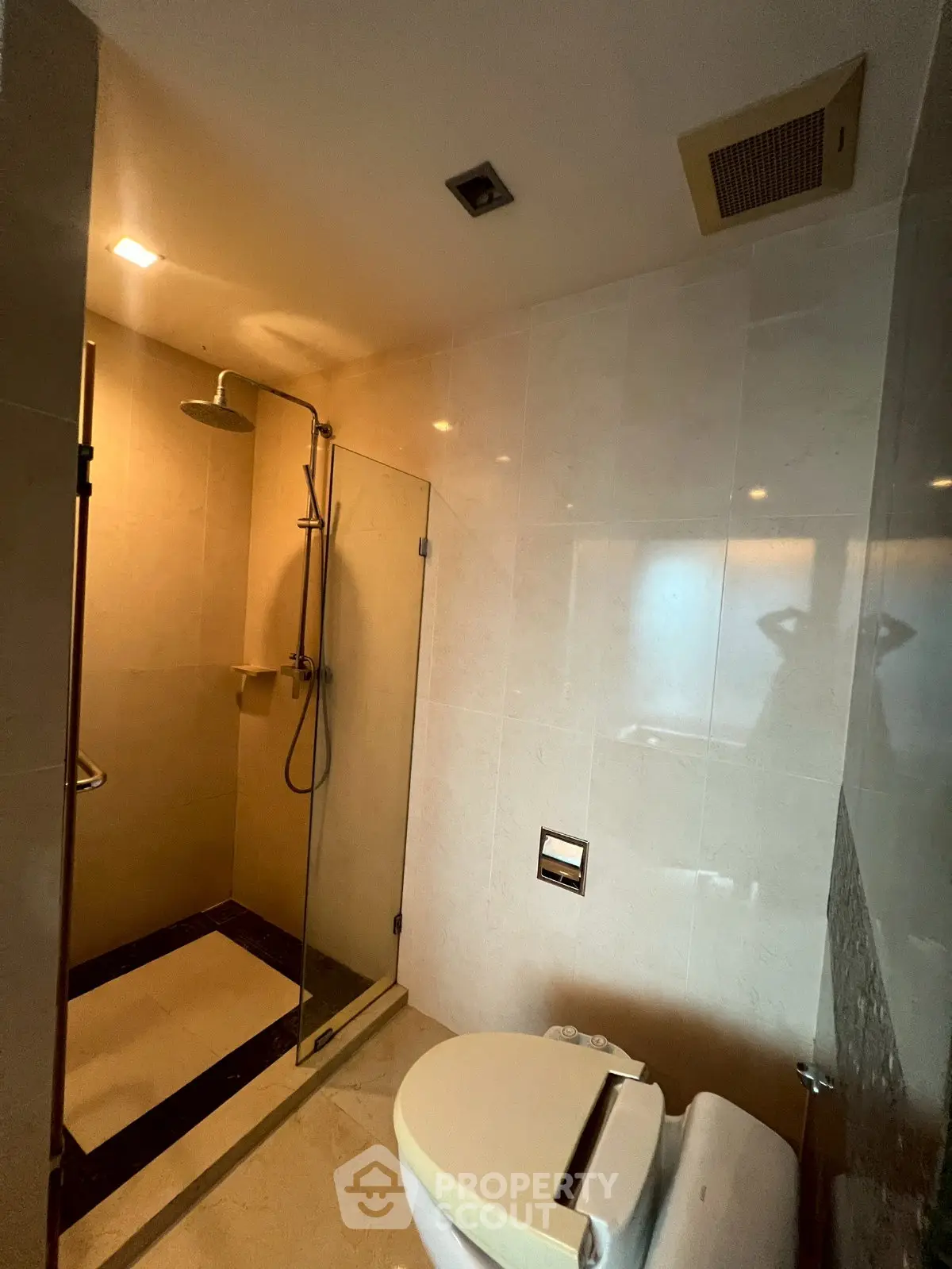 Modern bathroom with glass shower and sleek fixtures in luxury apartment.