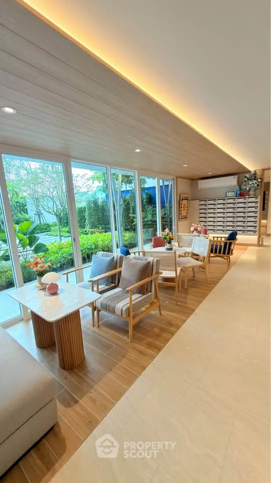 Elegant modern living area with large windows and garden view, featuring stylish furniture and natural light.