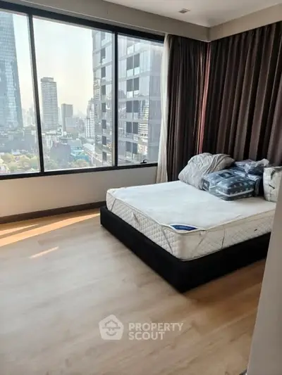 Modern bedroom with city view and large windows in high-rise apartment
