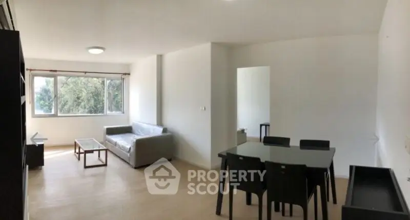 Spacious living room with modern furniture and large windows offering natural light.