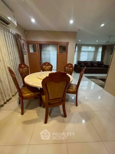 Elegant dining area with classic wooden furniture and spacious living room in modern home.