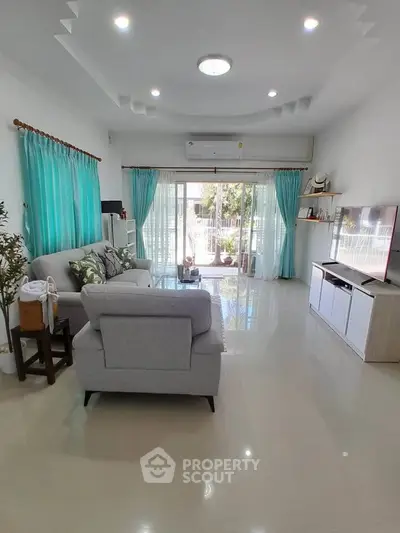 Spacious living room with modern decor and large windows for natural light.