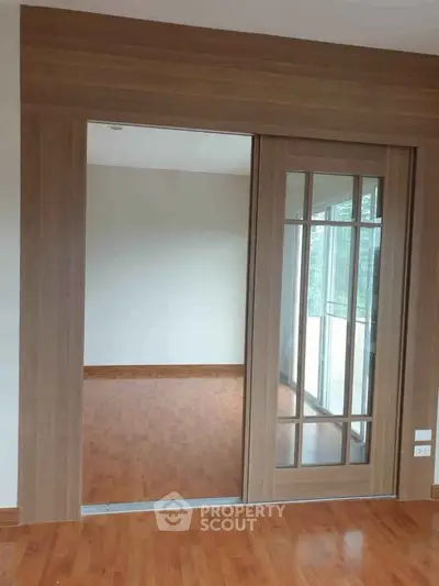 Spacious room with wooden sliding doors and elegant flooring