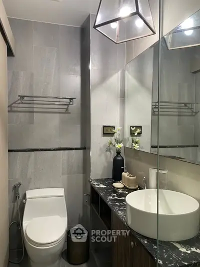 Modern bathroom with sleek fixtures and elegant design, featuring a stylish sink and contemporary lighting.