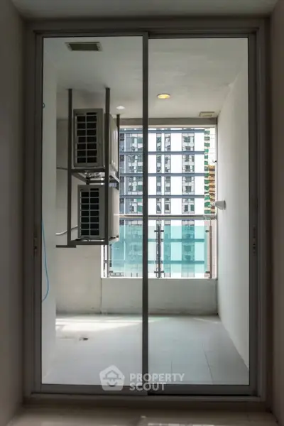 Modern balcony with glass doors and city view, perfect for urban living.