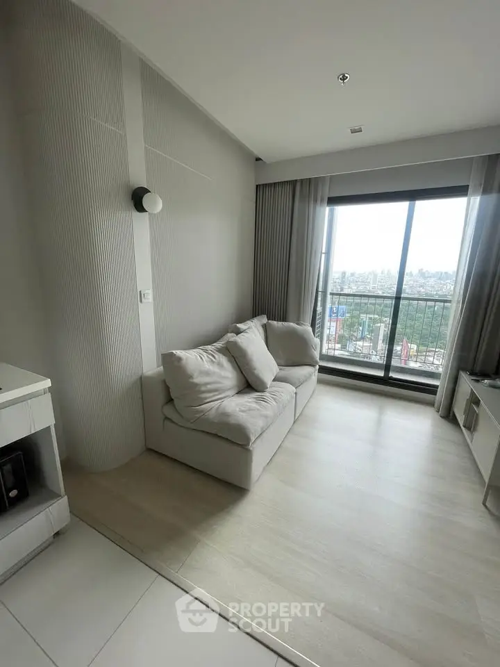 Modern living room with cozy sofa and large window offering city view