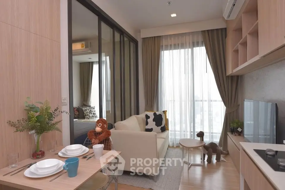 Modern living room with cozy decor and large windows in a stylish apartment.