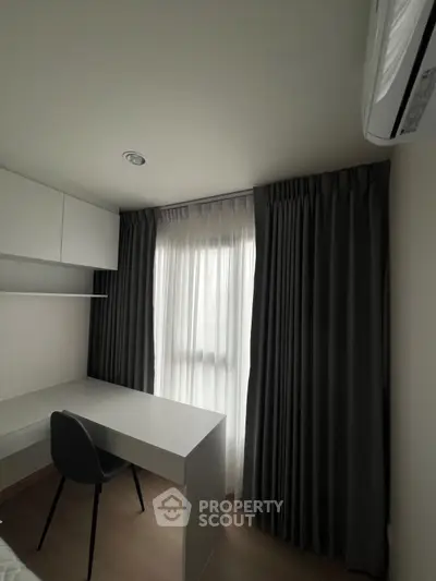 Modern study room with sleek desk and chair, featuring elegant curtains and built-in storage.