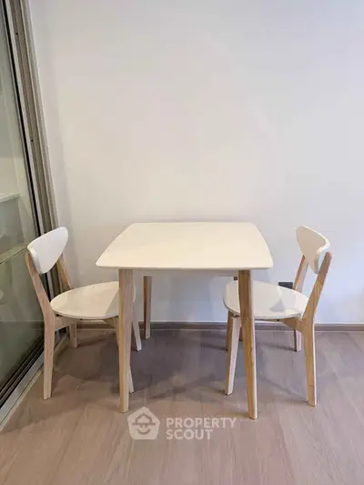 Minimalist dining area with modern table and chairs in a bright interior space.