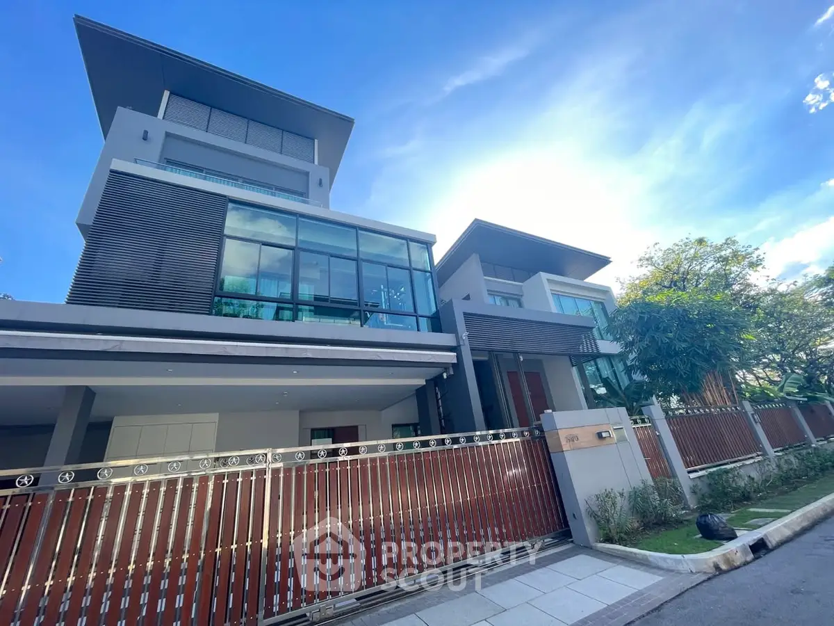 Luxurious modern house with sleek design and large windows under a clear blue sky.