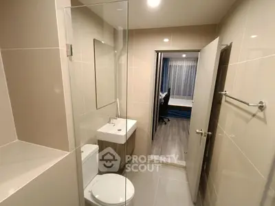 Modern bathroom with sleek design and view into adjacent bedroom