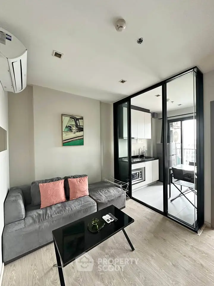 Modern living room with sleek design and open kitchen layout in a stylish apartment.