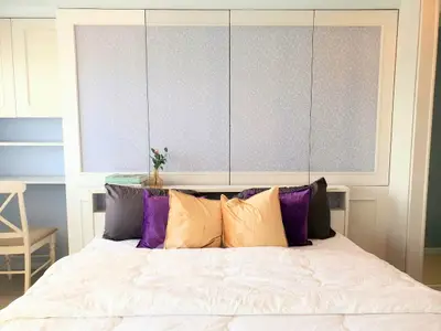 Cozy bedroom with stylish pillows and elegant decor, perfect for relaxation and comfort.