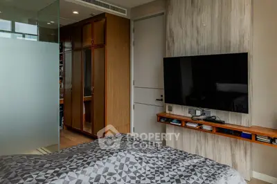 Modern bedroom with wall-mounted TV and stylish wardrobe in a contemporary apartment.
