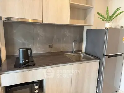 Modern kitchen with sleek cabinetry, compact appliances, and stylish backsplash.