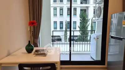 Modern apartment with balcony view, featuring a cozy study area and sleek appliances.
