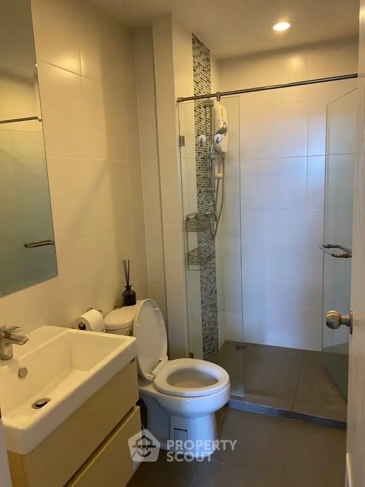 Modern bathroom with glass shower and sleek fixtures in a contemporary apartment.