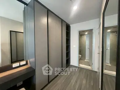 Modern bedroom with sleek wardrobe and en-suite bathroom in stylish apartment