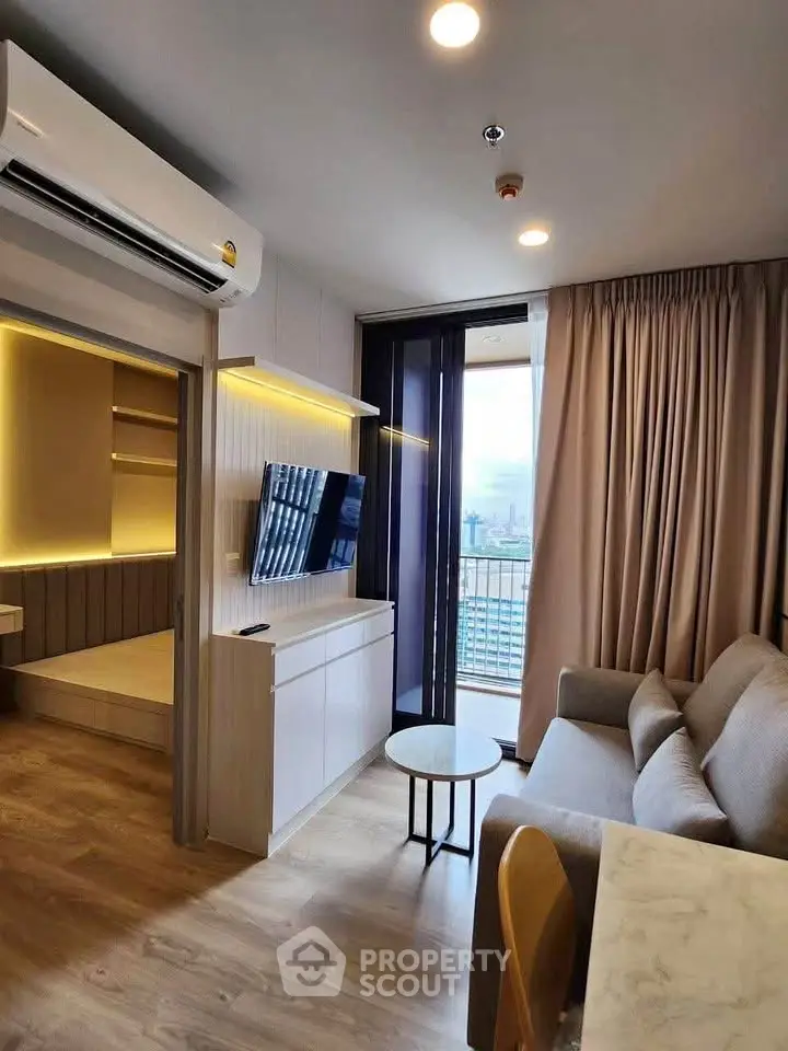 Modern living room with balcony view, featuring sleek furniture and ambient lighting.