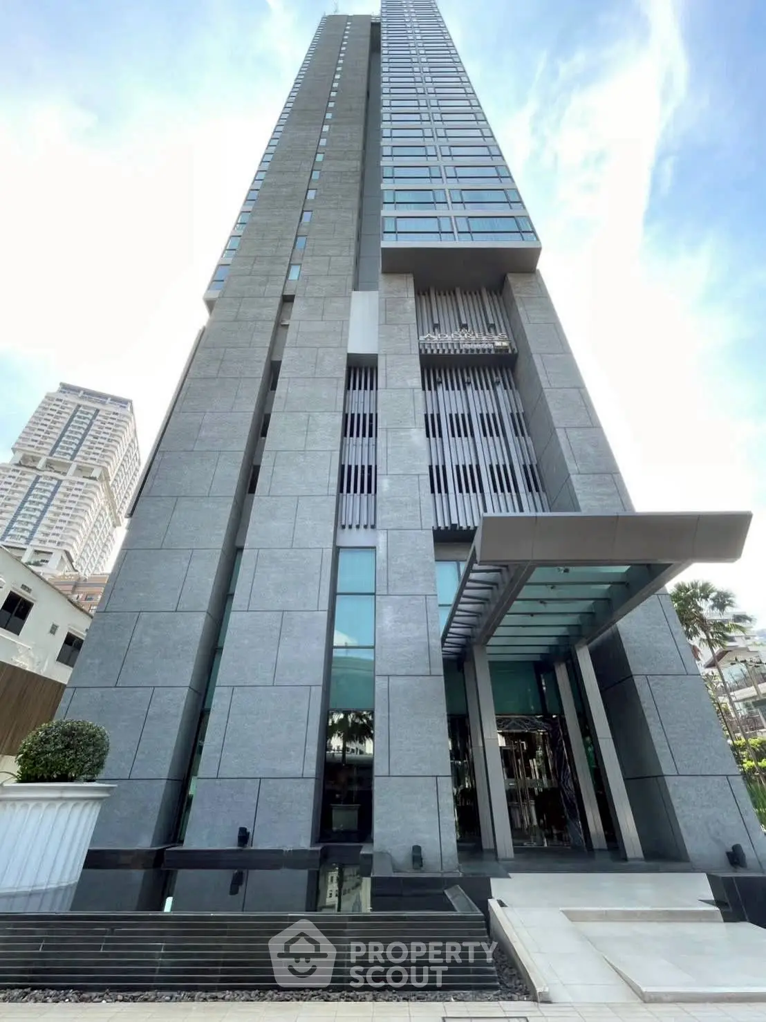 Stunning modern high-rise building with sleek architecture and impressive entrance in urban setting.