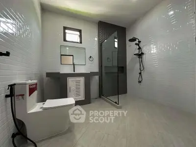 Spacious modern bathroom with sleek fixtures and glass shower enclosure