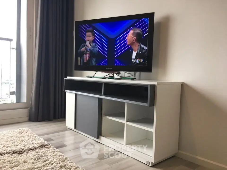 Modern living room with sleek TV stand and flat-screen TV, featuring stylish decor and cozy ambiance.