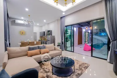 Luxurious open-plan living room with modern kitchen and pool view, perfect for entertaining.