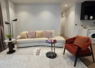 Modern living room with stylish furniture and washing machine in corner