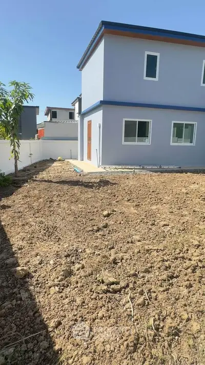 Modern two-story house with spacious backyard and clear blue sky