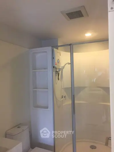Modern bathroom with sleek shower enclosure and built-in storage.