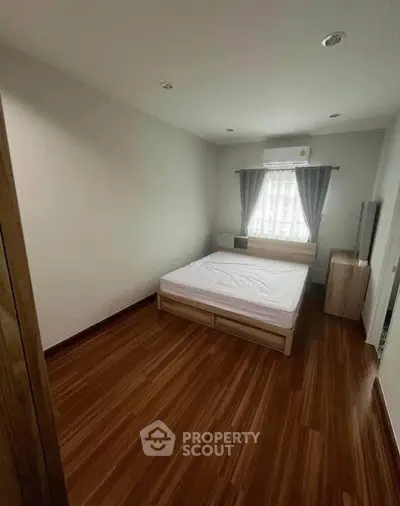 Cozy bedroom with wooden flooring and natural light