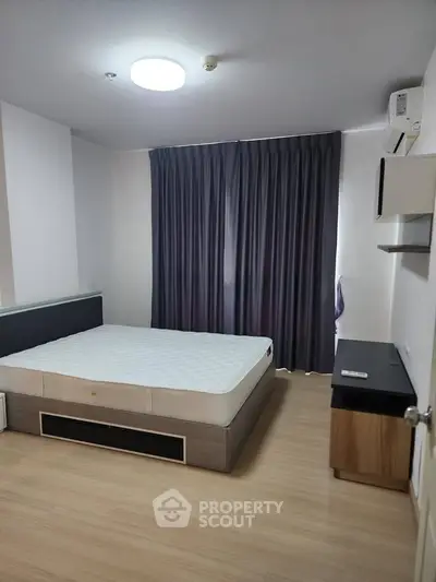 Spacious bedroom with modern design and natural light, featuring a comfortable bed and stylish furnishings.
