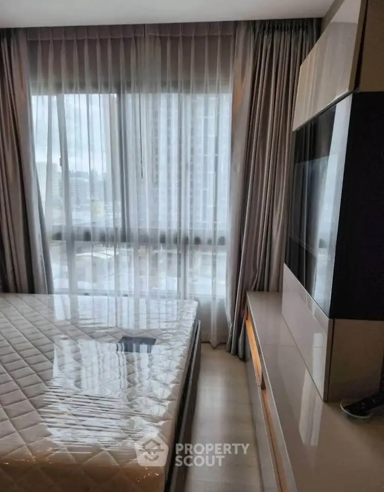 Modern bedroom with large window and sleek furniture in urban apartment