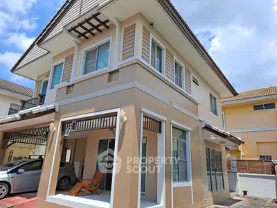 Charming two-story house with modern design and carport in a sunny neighborhood.