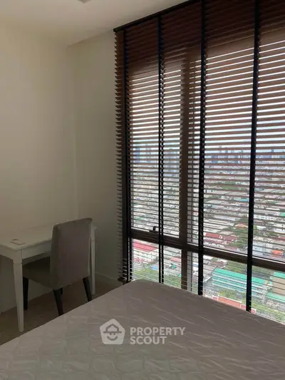 Modern bedroom with city view, featuring large windows and stylish blinds, perfect for urban living.