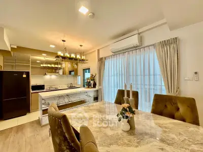 Luxurious open-layout kitchen and dining area with marble table and modern appliances.