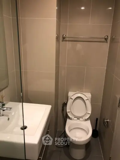 Modern bathroom with sleek fixtures and neutral tiles, perfect for a contemporary home.