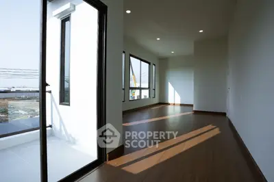 Spacious modern living room with large windows and wooden flooring