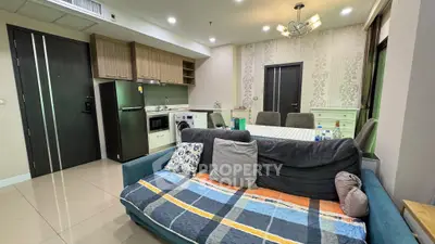 Modern open-plan living room with kitchen featuring sleek appliances and cozy seating area.