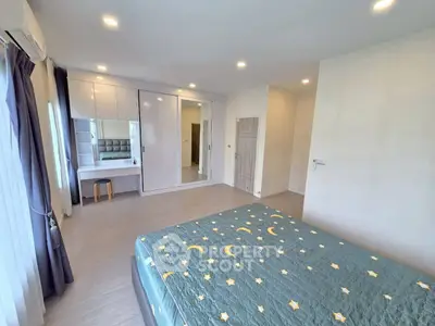 Spacious bedroom with modern decor and ample natural light, featuring a stylish bed and built-in wardrobe.