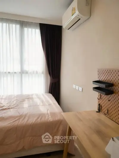 Cozy bedroom with natural light and modern furnishings in a stylish apartment.