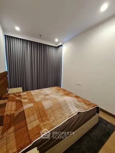 Cozy bedroom with modern decor and warm lighting, featuring a comfortable bed and stylish curtains.