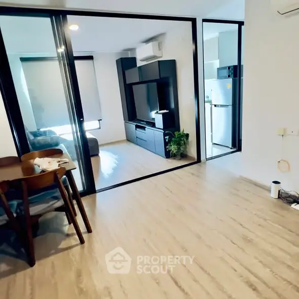 Modern open-plan living room with sleek furniture and kitchen area