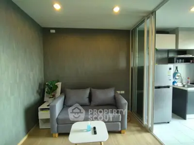 Modern living room with cozy sofa and open kitchen layout in stylish apartment.